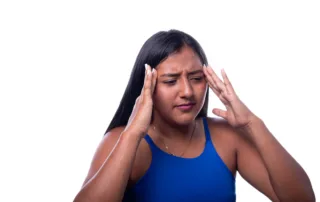 Person holding head with both hands, illustrating Ozempic-related headache