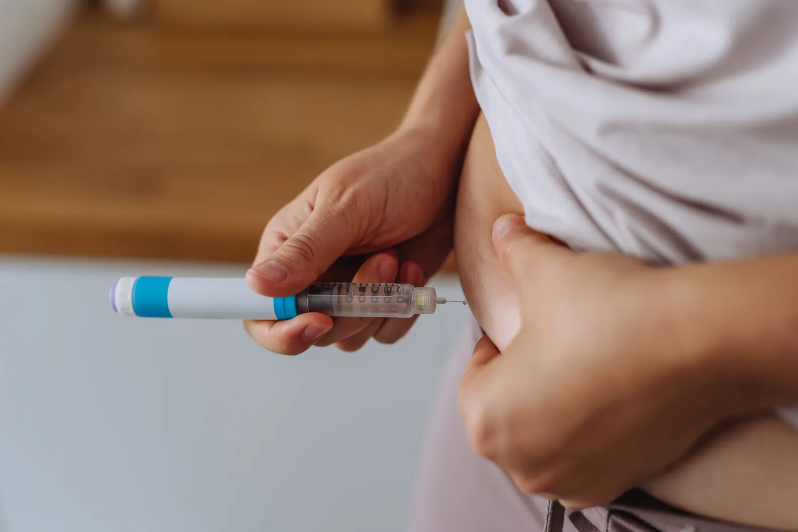 Person injecting Tirzepatide with insulin pen, showing self-administration of compounded Mounjaro