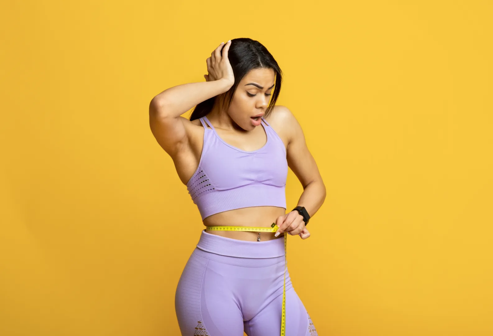 Person measuring waist to track body composition during Ozempic weight loss journey